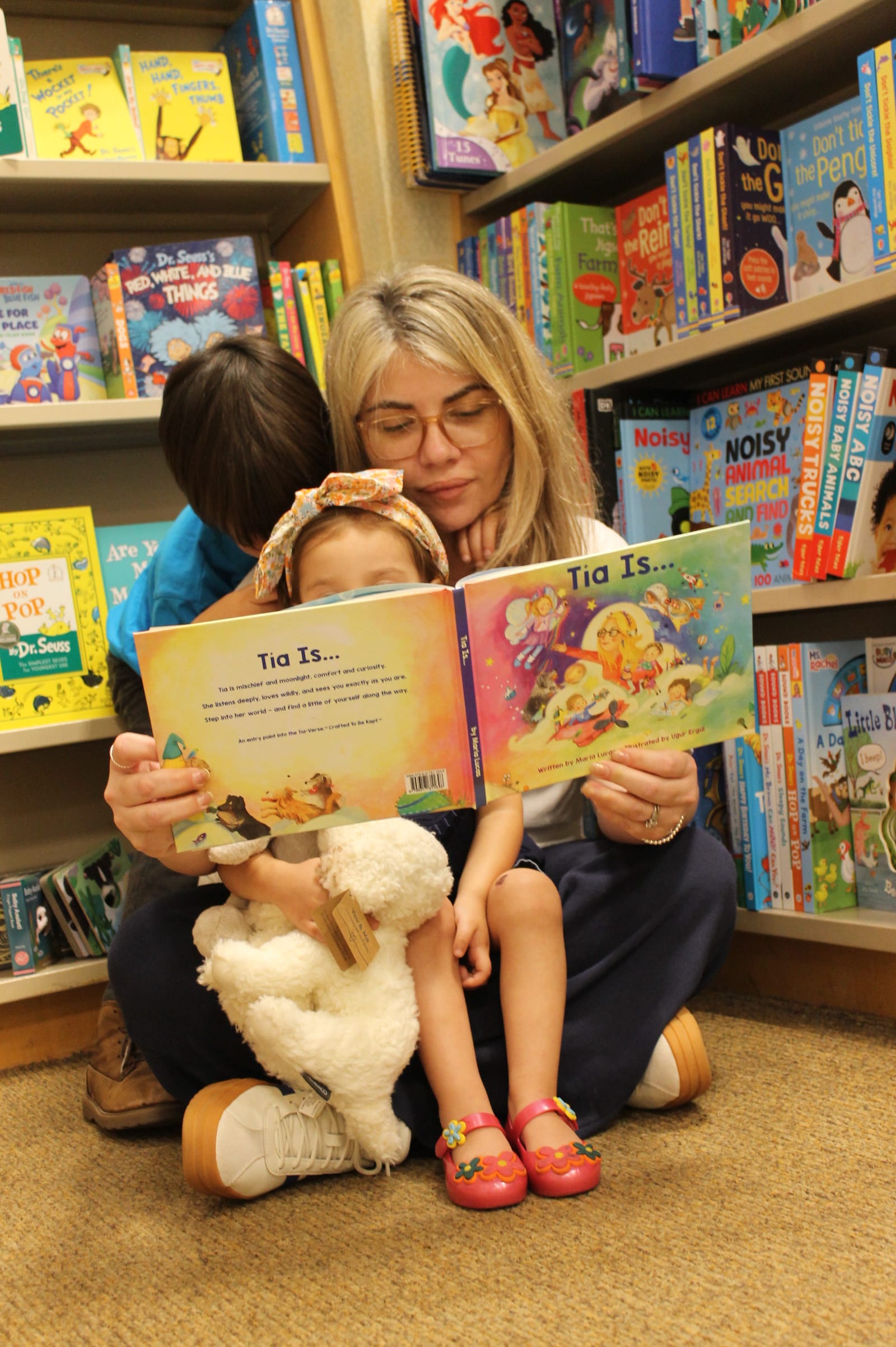 A grownup reading Tía Is… with two children